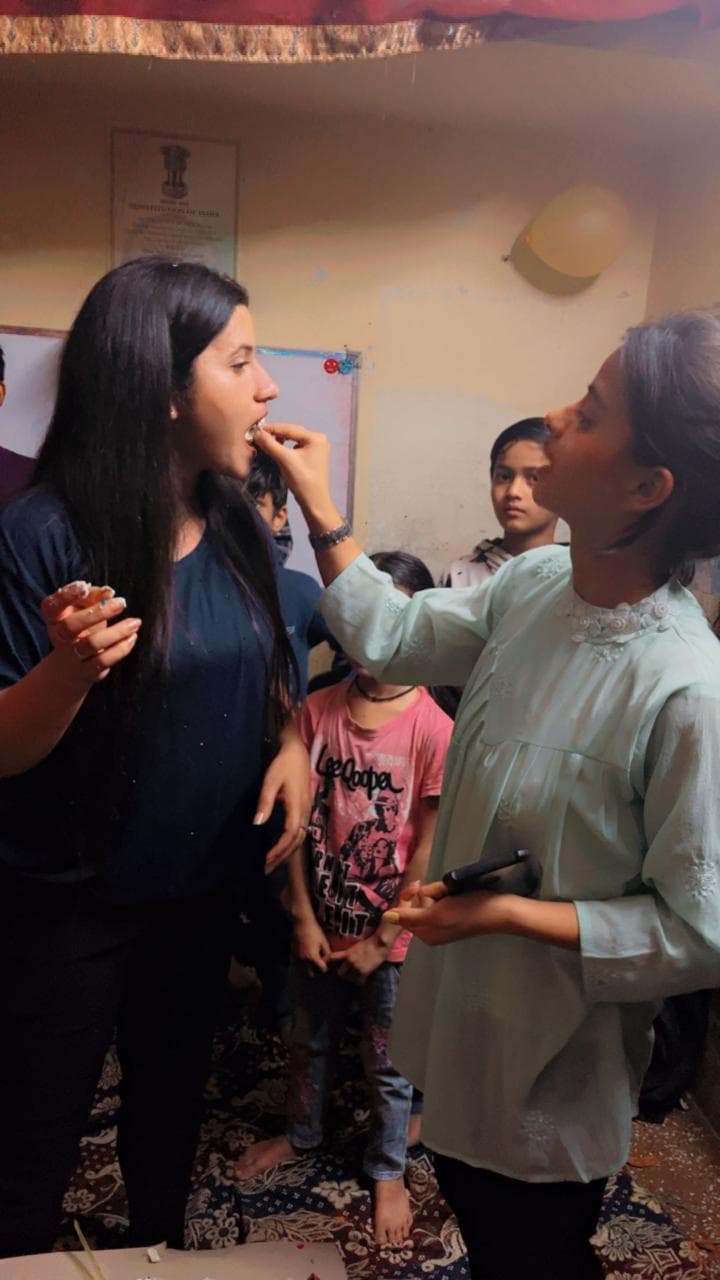Tanuja Singh being fed cake by a student