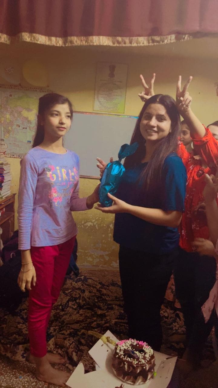 Tanuja Singh giving a gift to a student